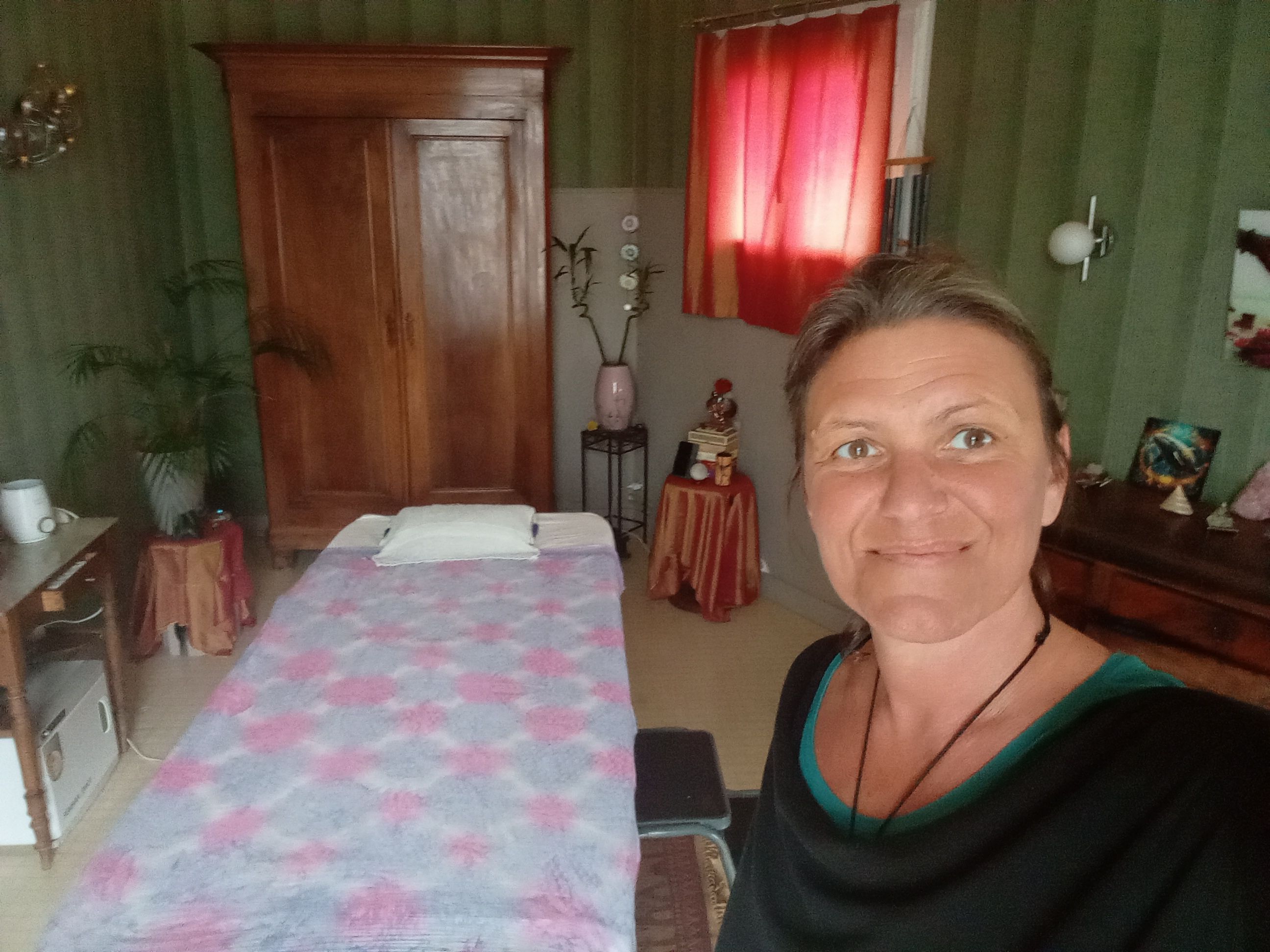 Isabelle dans son cabinet, avec la table de massage et le mobilier en bois